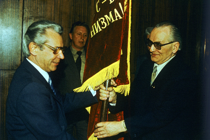 1986.a üleliidulises sotsialistlikus võistluses esikoha võitnud I.M. Kirovi nim näidiskalurikolhoosile määratud NLKP Keskkomitee, NSV Liidu Ministrite Nõukogu, Üleliidulise Ametiühingute Kesknõukogu ja ÜLKNÜ Keskkomitee rändlipu annab kolhoosi esimehele sotsialistliku töö kangelasele Oskar Kuulile üle EKP Keskkomitee II sekretär Georgi Aljošin.
