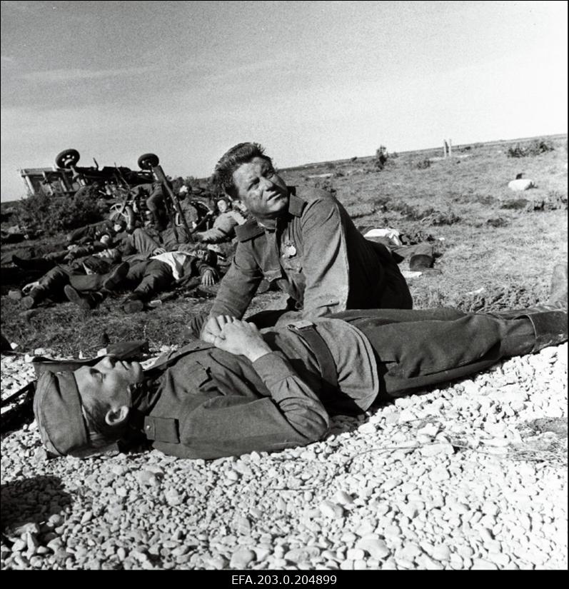 Stseen Tallinnfilmi mängufilmist "Inimesed sõdurisinelis". Langenud relvavenna Viiese (Kenno Oja) kõrval on Tääger (Heino Raudsik).