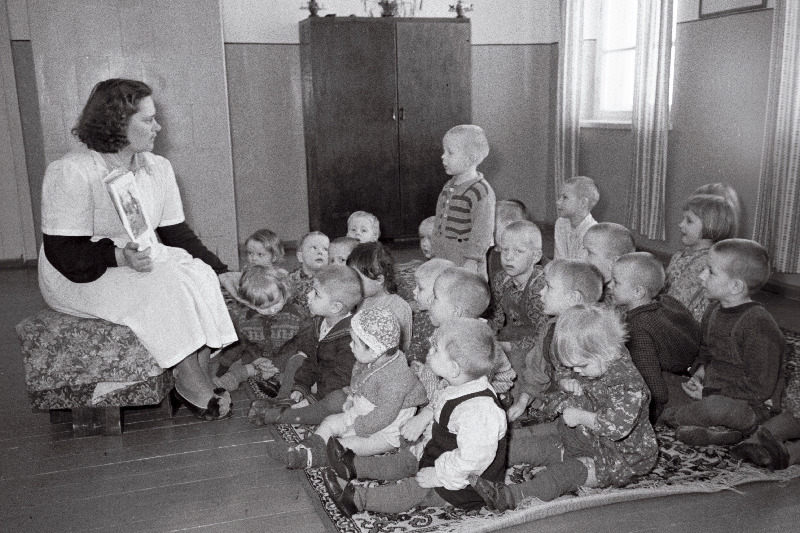 Rahnoja sovhoosi lasteaia juhataja J. Jakobson lastele pildiraamatut näitamas.