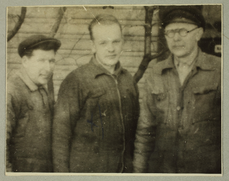 Fotol seisavad kolm meest, keskmine neist on Evald Nurmsalu Augusti p.