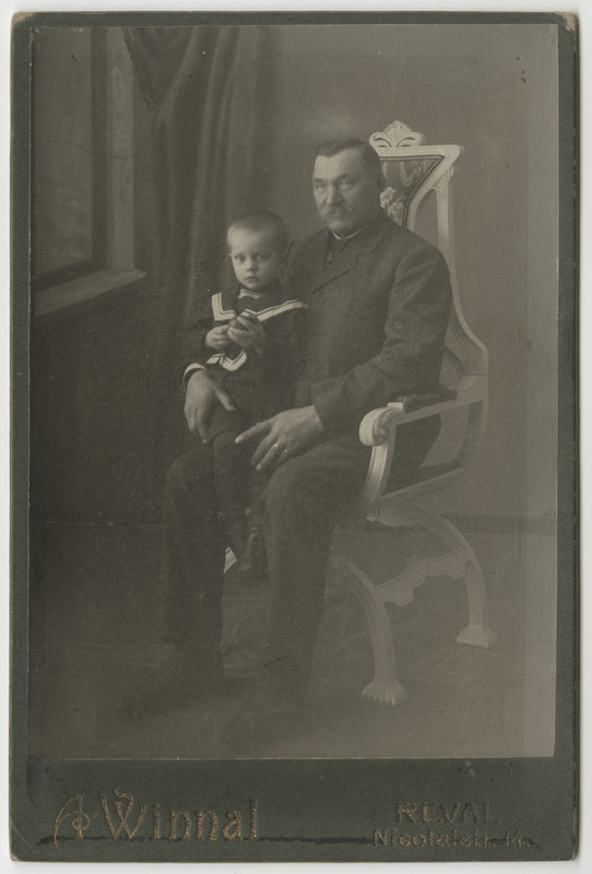 Mees toolil koos väikse lapsega toolil istumas