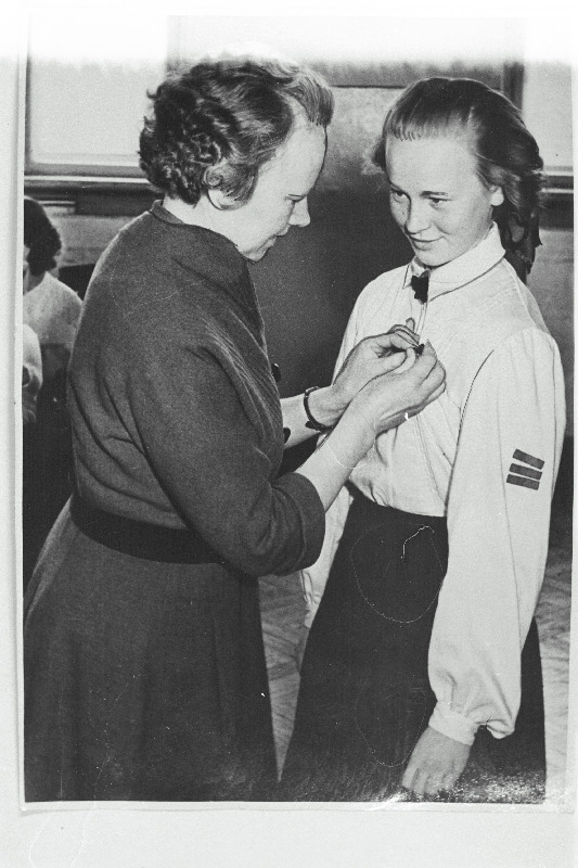 Revolutsionäär Olga Lauristin Tallinna 16. Keskkooli õpilasele E. Laagerile komsomolimärki rinda kinnitamas.