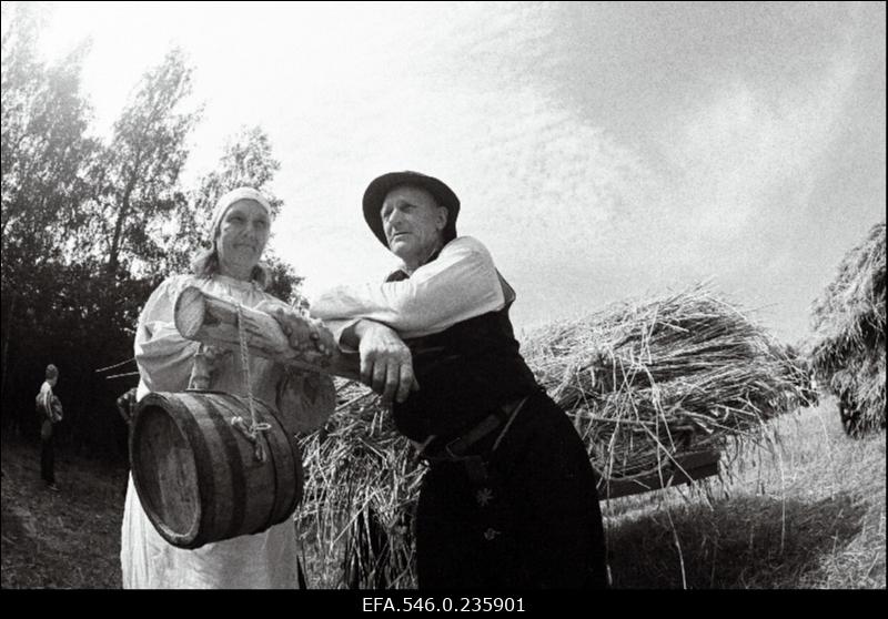 Lõikuspüha. Mees ja naine põllutöömasina juures.