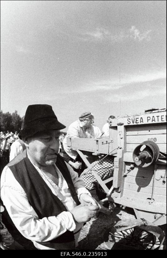 Lõikuspüha. Mees masinat seadistamas.