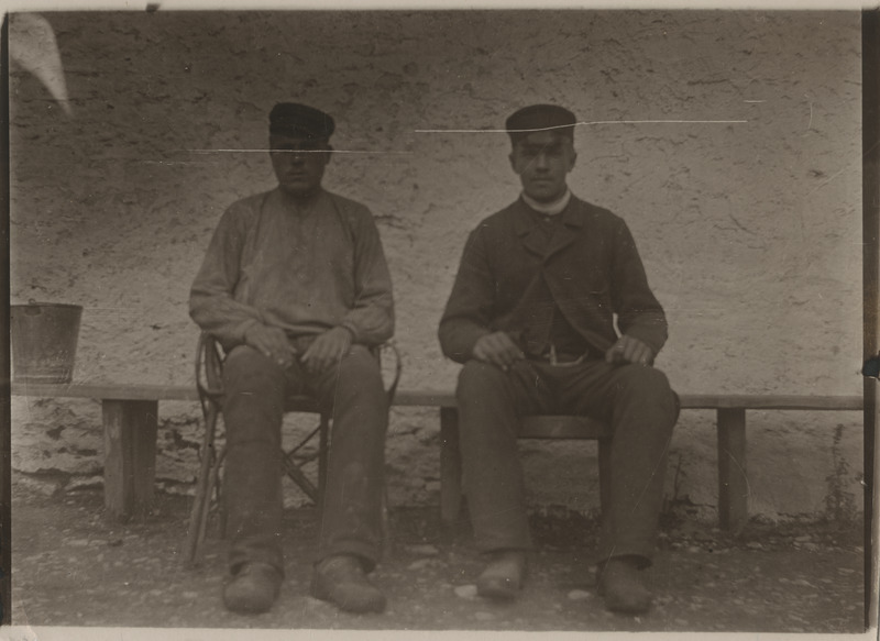 Kaks mees istumas hoone taustal