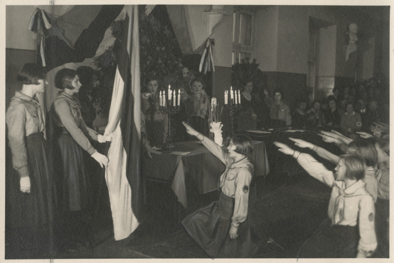 Kodutütred lipu ees põlvitades vandetõotust andmas