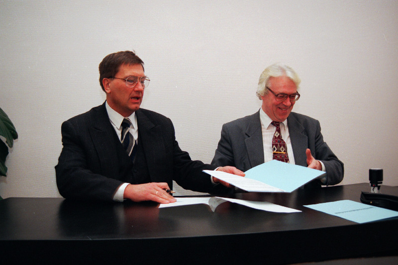 Justiitsministeeriumi kantsler Mihkel Oviir (vasakul) ja Sõnumilehe vastutav väljaandja Toomas Leito kirjutavad alla lepingule, mille kohaselt Sõnumileht jätkab 1997.aastal ametlike teadete avaldamist.