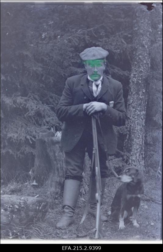 Nöörmann jahipüssi ja koeraga looduses.