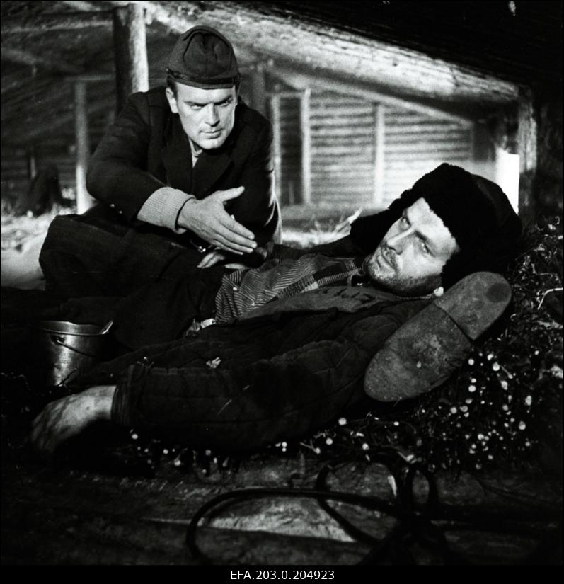 Stseen Tallinnfilmi mängufilmist "Inimesed sõdurisinelis". Reinop (Peeter Kard) püüab Kalmu (Rudolf Allabert) veenda.