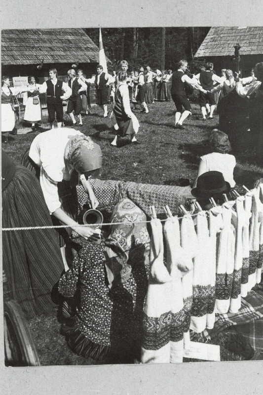 Kihnu naiste käsitööde näitus Eesti NSV Riiklikus Vabaõhumuuseumis. Tagaplaanil tantsivad soome rahvatantsijad.