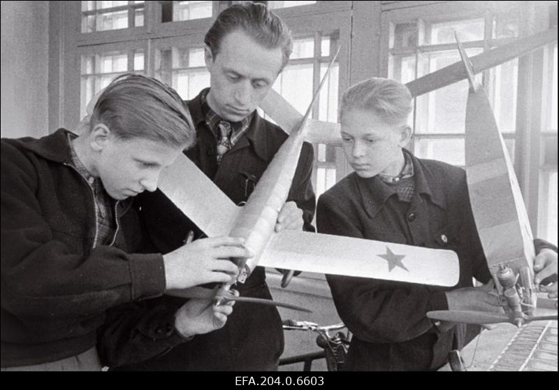 Rakvere Pioneeride Maja mudellennuringi juhataja A. Leet (keskel) tutvustab ringi liikmeid V. Ivanovi (vasakul) ja A. Rammot mudellennuki konstruktsiooniga.