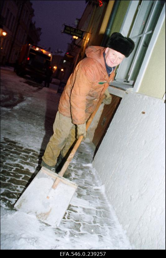 Käsitsi lumekoristus linnatänaval.