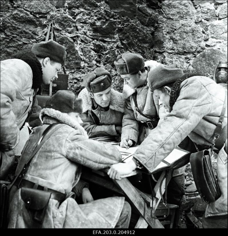 Stseen Tallinnfilmi mängufilmist "Inimesed sõdurisinelis". Lahingut valmistavad ette (vasakult) Tisler (Rein Juurik), Agur (Tõnu Mikiver), sõjamees (Evald Aavik), leitnant Aava (Arne Laos), Mänd (Leonhard Merzin).