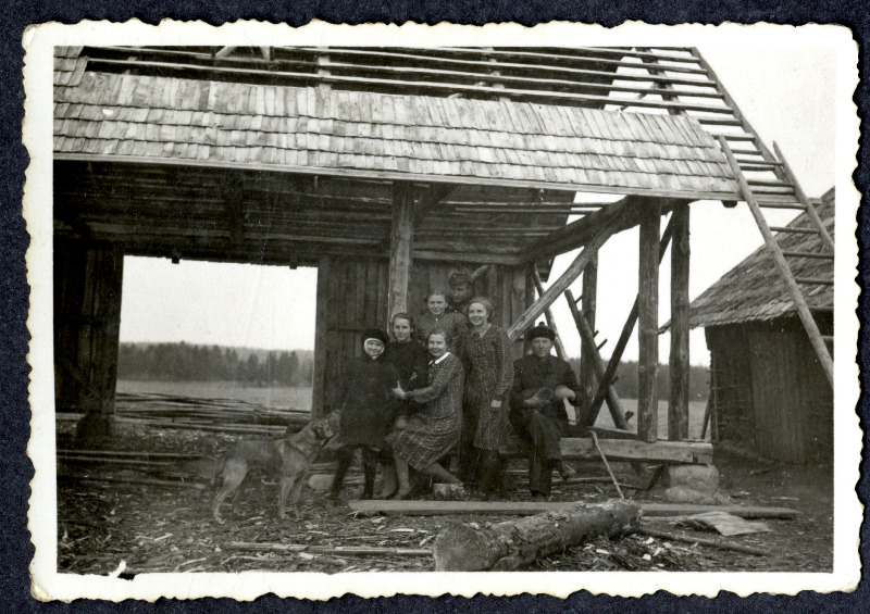 Seitsmeliikmeline seltskond koos koeraga ehitusjärgus maja juures