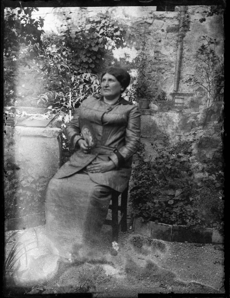 [Portrait] - Portrait of a woman sitting with a fan in her hand.