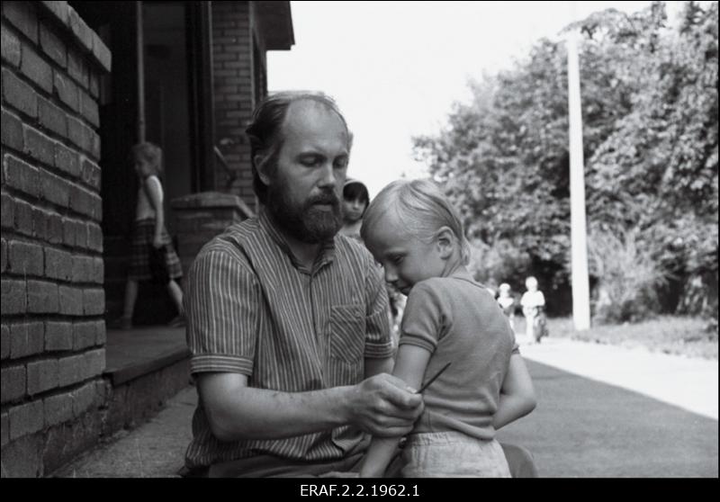 Tallinna Linnavalitsuse sotsiaalnõunik Tõnu Karu kükitab lapse kõrval