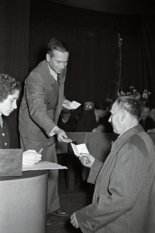 Kalinini-nimelise Veduriremonditehase tehasekomitee esimehe asetäitja J. Zolotarjevski annab vanale töölisele Jaan Kiislale üle pensioniraamatu.