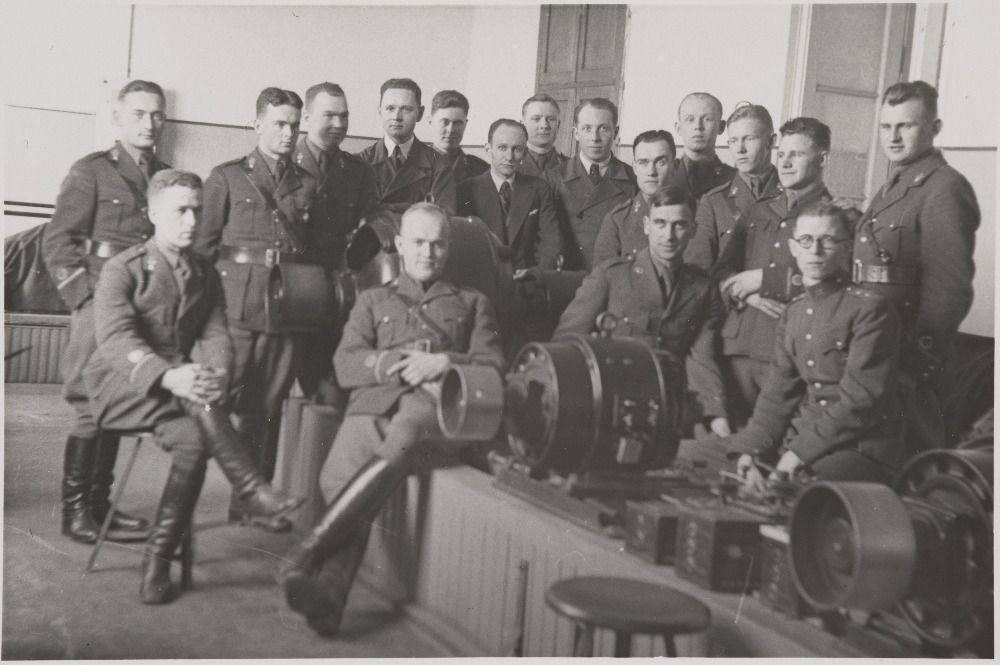 Eesti Vabariigi Sõjaväe Tehnikakool.Pürotehnikaklass elektrotehnika praktikumis.Istuvad vasakult lipnikud M.Purgas, A.Aarna, leitnandid J.Liiv ja P.Värk. Seisavad vasakult lipnikud K.Rõngelep, J.Luiker, E.Arumeel, TTÜ instruktorid  A.Vahari ja A.Pehka, H.Maidre. V.Karuse, J.Seks, O.Kornet, J.Priikask, I.E.Sepp, V.Anvelt, K.Saare.