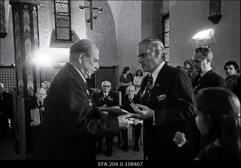 Revolutsioonilise liikumise ja kodusõja veteranide vastuvõtul Tallinna Raekojas annab EKP Tallinna Linnakomitee esimene sekretär N. Johanson Kommunistliku Partei liikmele 1917.a. G. Gustavsonile üle tervitusaadressi ja kingituse.