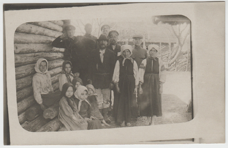Sõdurid koos talurahvaga ["Jürka" perekond] aias [Väike-Rjabtsova külas], esiplaanil lapsed ja naised, Villem Liiv nõjatumas küünarnukiga maja seinale