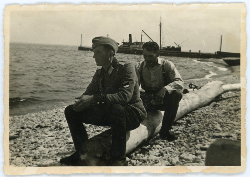 Kaks meest Pakri saare rannas palgil istumas, üks neist Eesti Leegioni mundris ja eraldusmärkidega