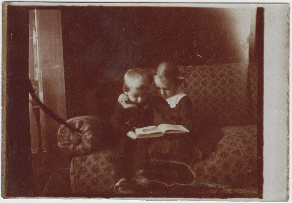 Kaks last diivanil raamatut vaatamas. Võimalik, et Jaan Tõnissoni tütar Hilja ja poeg Lembit-Rein