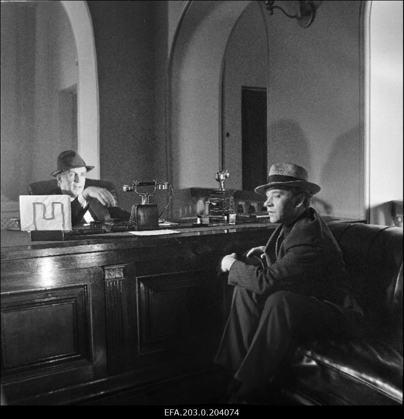 Stseen Tallinnfilmi mängufilmist "Bande". Istuvad Paul Madving (Aarne Üksküla) ja Ned Beamount (Tõnu Kark).