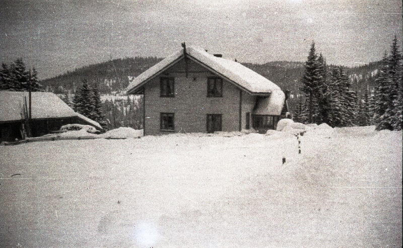 Vaade majale lumiste mägede taustal [Skandinaavias?]