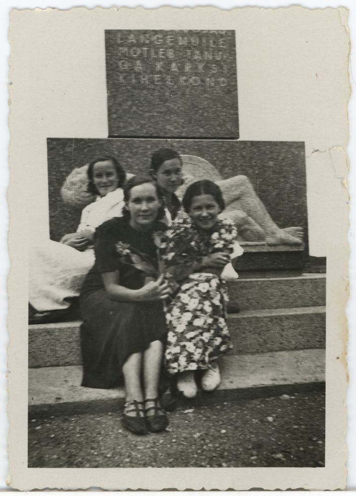 Neli noort naist Karksi-Nuia vabadussamba ees istumas, taga vasakul Salme Maling (Maimre)