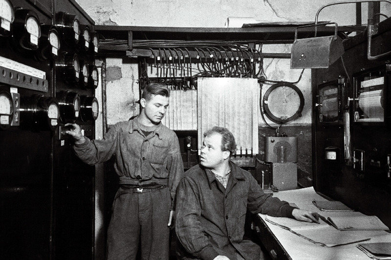 Kiviõli Kombinaadi katsetsehhi juhtpuldi vanemelektrik E. Innus (paremal) ja lukksepp N. Ostretsov seadmeid kontrollimas.