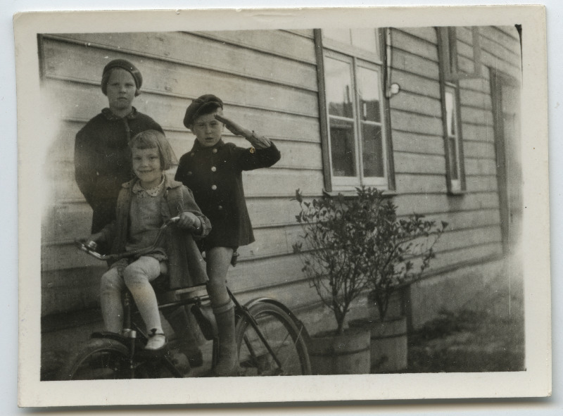 Lapsed [kaks nooremat Gustav Jakobsoni lapsed?] jalgrataga maja seina ääres