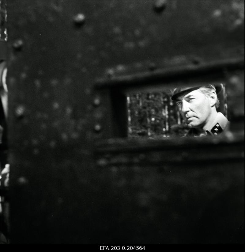 Stseen Tallinnfilmi mängufilmist "Hullumeelsus". Auto tagavaatepeeglis peegeldub Saksa leitnandi (Harijs Liepiņš) nägu.
