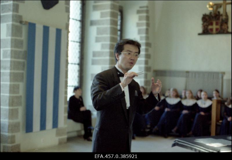 Tütarlastekoori Ellerhein kohtumine Jaapani kooriga Tallinna Raekojas. Dirigeerib Jaapani koorijuht, tagaplaanil istub koorijuht Tiia-Ester Loitme (vasakul) oma koori liikmetega.