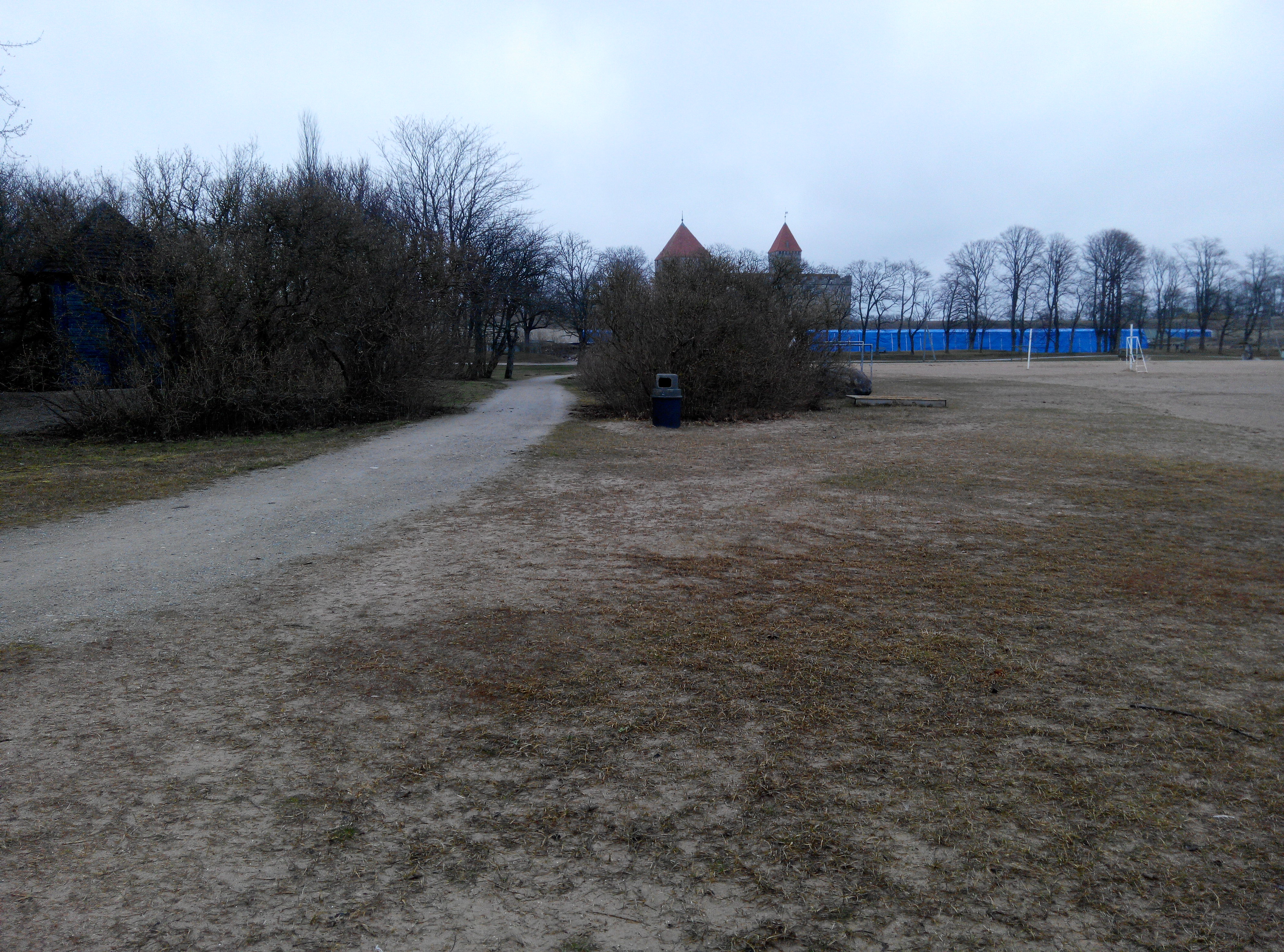 Kuressaare rand, suvitajad murul istumas, taamal rannakohvik ja linnuse tornid rephoto