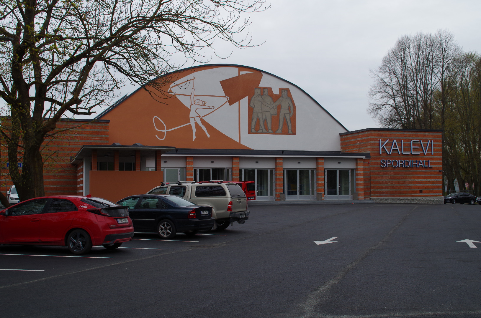 Kalevi spordihall, vaade halli otsafassaadile, ees muru. Arhitektid Uno Tölpus, Peeter Tarvas, Olga Kontšajeva rephoto