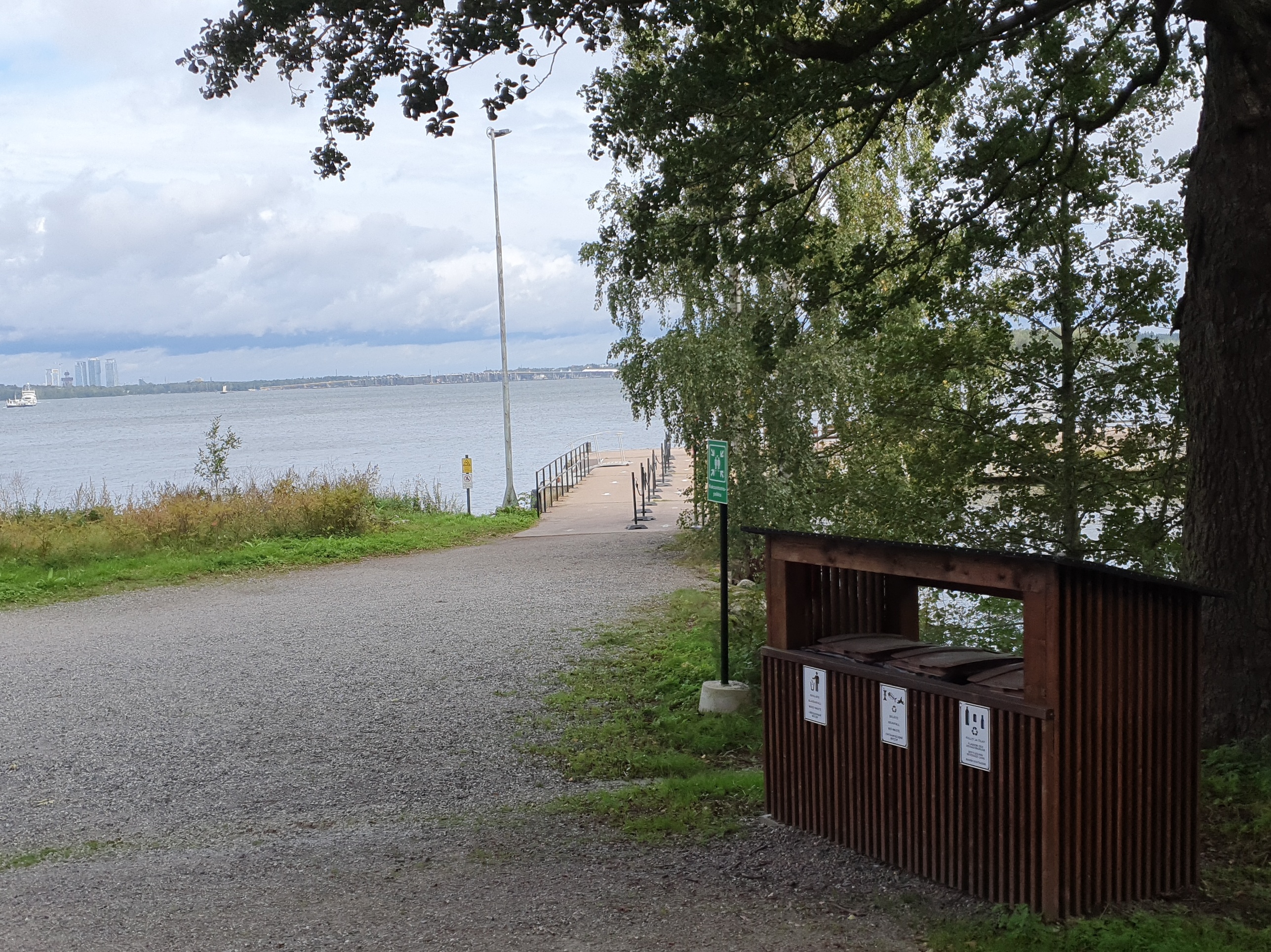 Väkeä Vallisaaren Päälaiturin luona. Ihmiset jonottavat pääsyä vartiolle näyttääkseen kulkulupansa saavuttuaan veneellä saareen. Vallisaari oli alunperin venäläisen varuskunnan käytössä ollut saari ja Suomen itsenäistymisen jälkeen Suomen armeijan käytössä, ja siten pääsy saarelle oli luvanvaraista. Valokuva on otettu saaren pohjoisrannasta. On kevät ja maassa on vielä jäämiä lumesta ja jäästä. rephoto