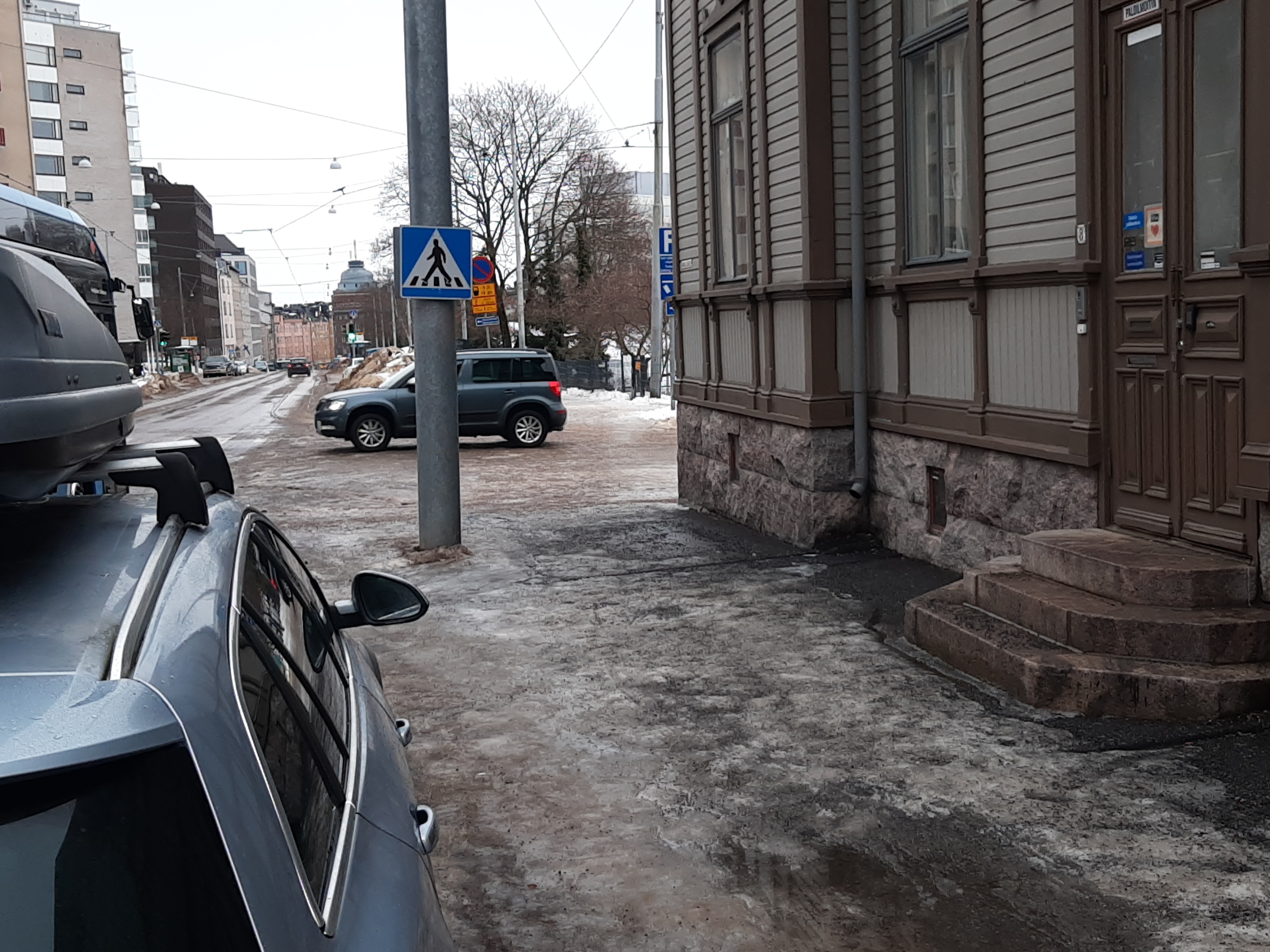 Toinen linja 8. Jalankulkijoita, kolme miestä, nainen sekä poika polkuautonsa kanssa, kävelemässä Toinen linja 6:n (nykyisin 8) puutalon edustalla. Jalkakäytävällä sementtilaatat. Näkymä Hakaniemen suuntaan. rephoto