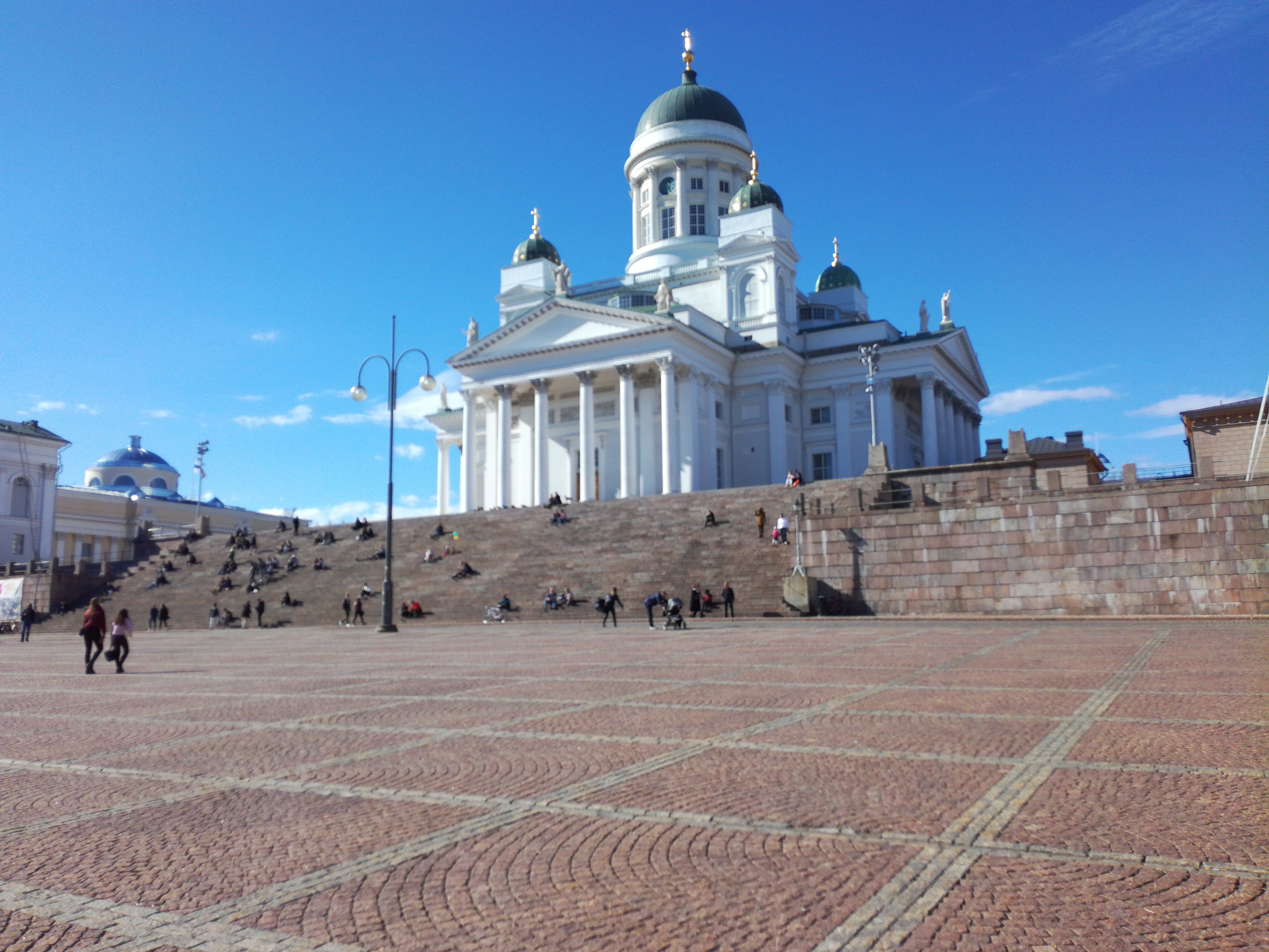 Tourists at the Senate Square in Helsinki, background Toomkirik rephoto