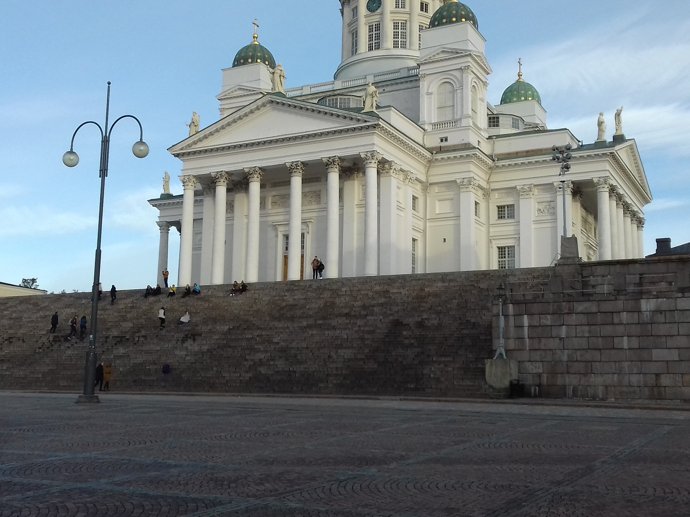 Tourists at the Senate Square in Helsinki, background Toomkirik rephoto