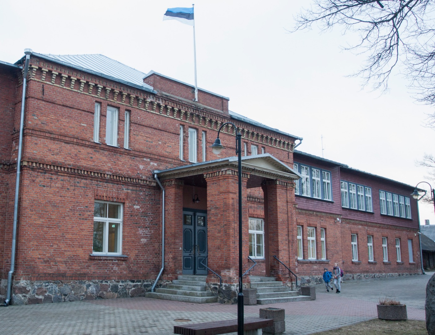 Viljandi Eesti Põllumeeste Seltsi maja. Trepil istub M. Kampmann. rephoto