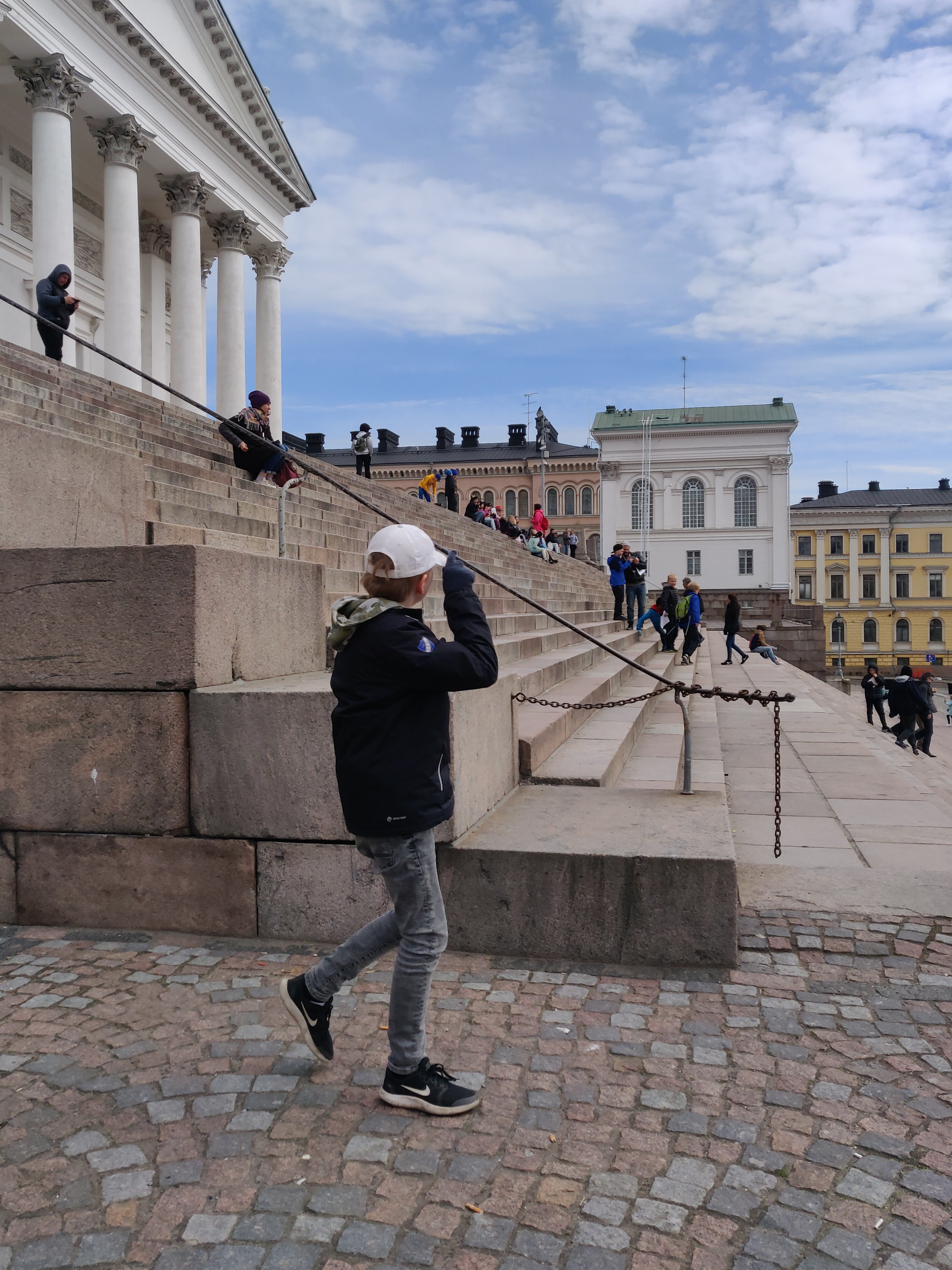 Kaupunkilaisia istumassa Tuomiokirkon portailla. rephoto