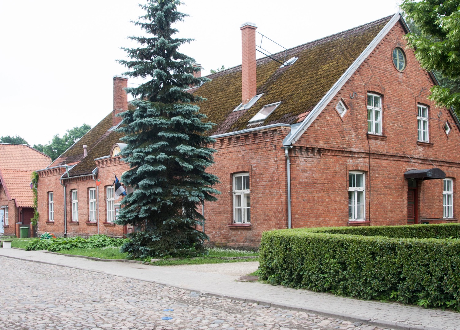 Kaunistustega aluspapiga fotol maja puiestee ääres, Viljandis. rephoto