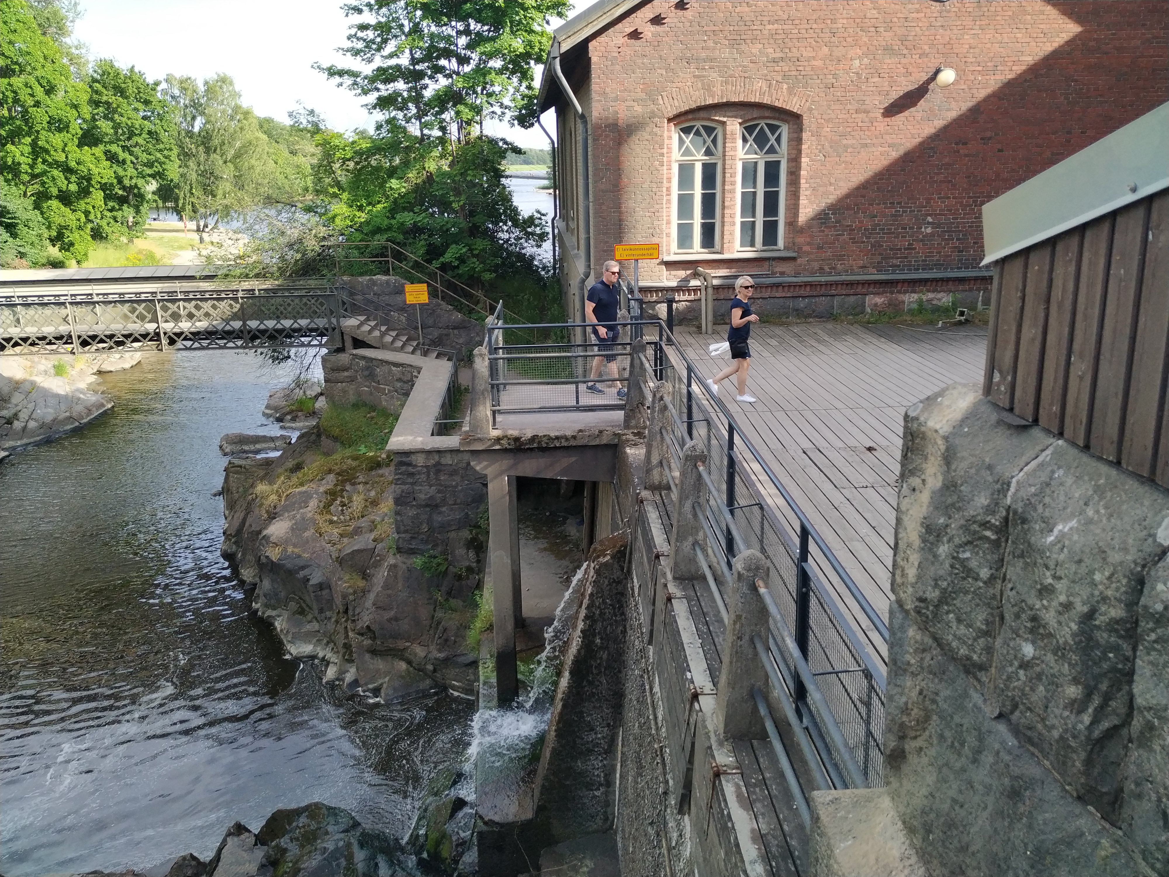 Ihmisiä Vanhankaupunginkoskella jäidenlähdön aikaan. Yksi mies maalaamassa. rephoto