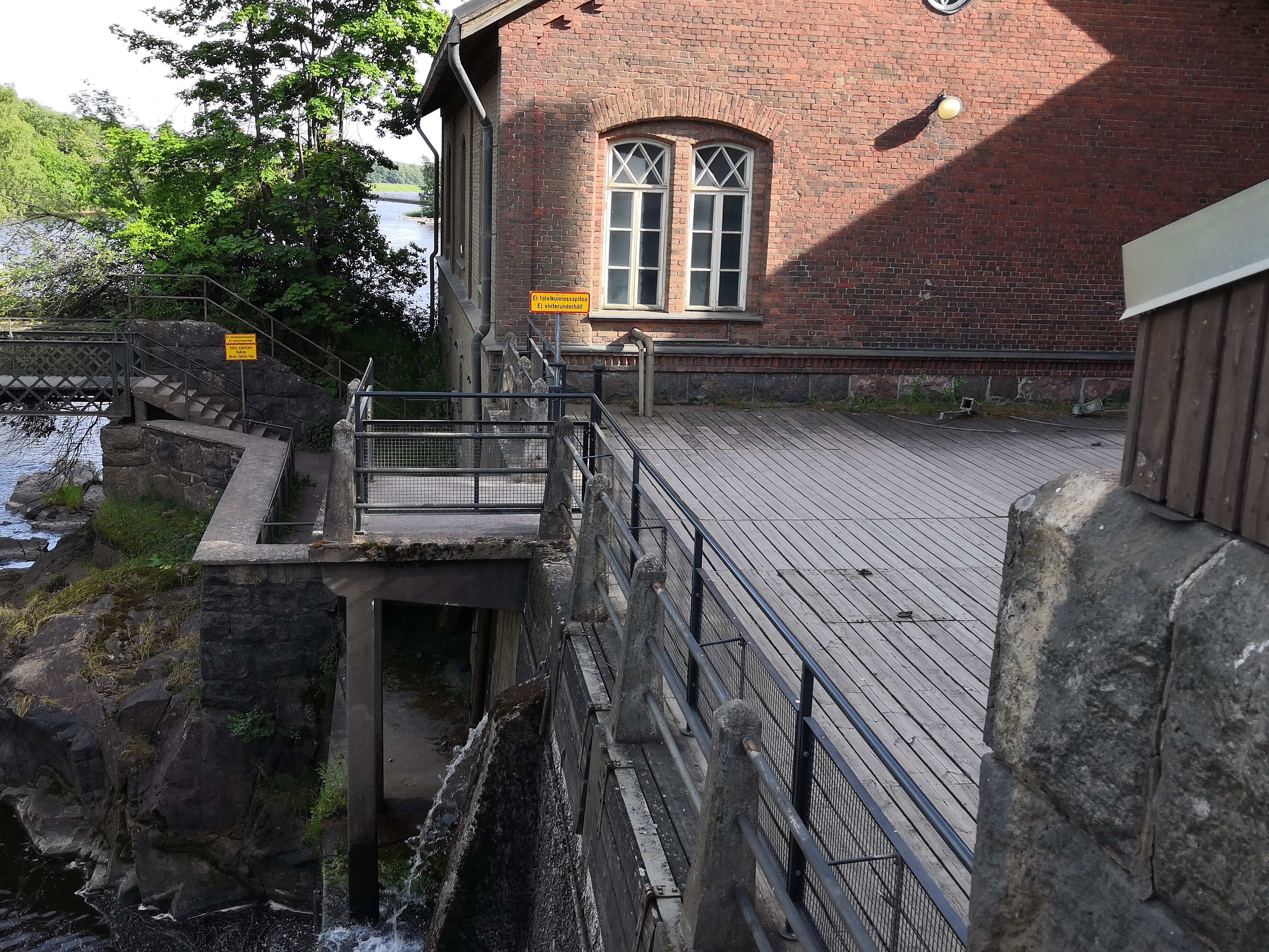 Ihmisiä Vanhankaupunginkoskella jäidenlähdön aikaan. Yksi mies maalaamassa. rephoto