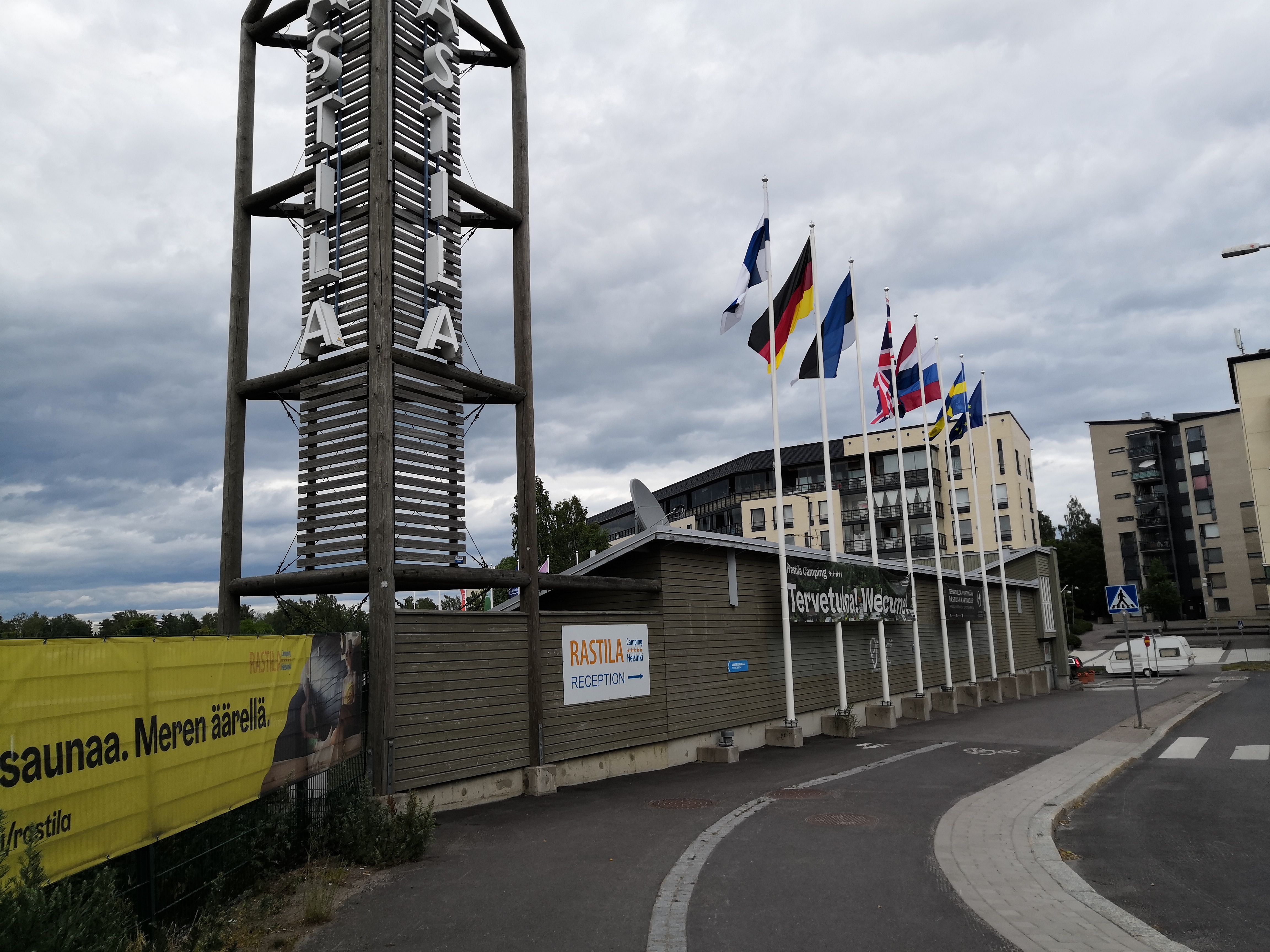 Kesäinen Rastilan leirintäalue. Etualalla vastaanottorakennus, jonka edessä liehuu eri maiden lippuja. rephoto