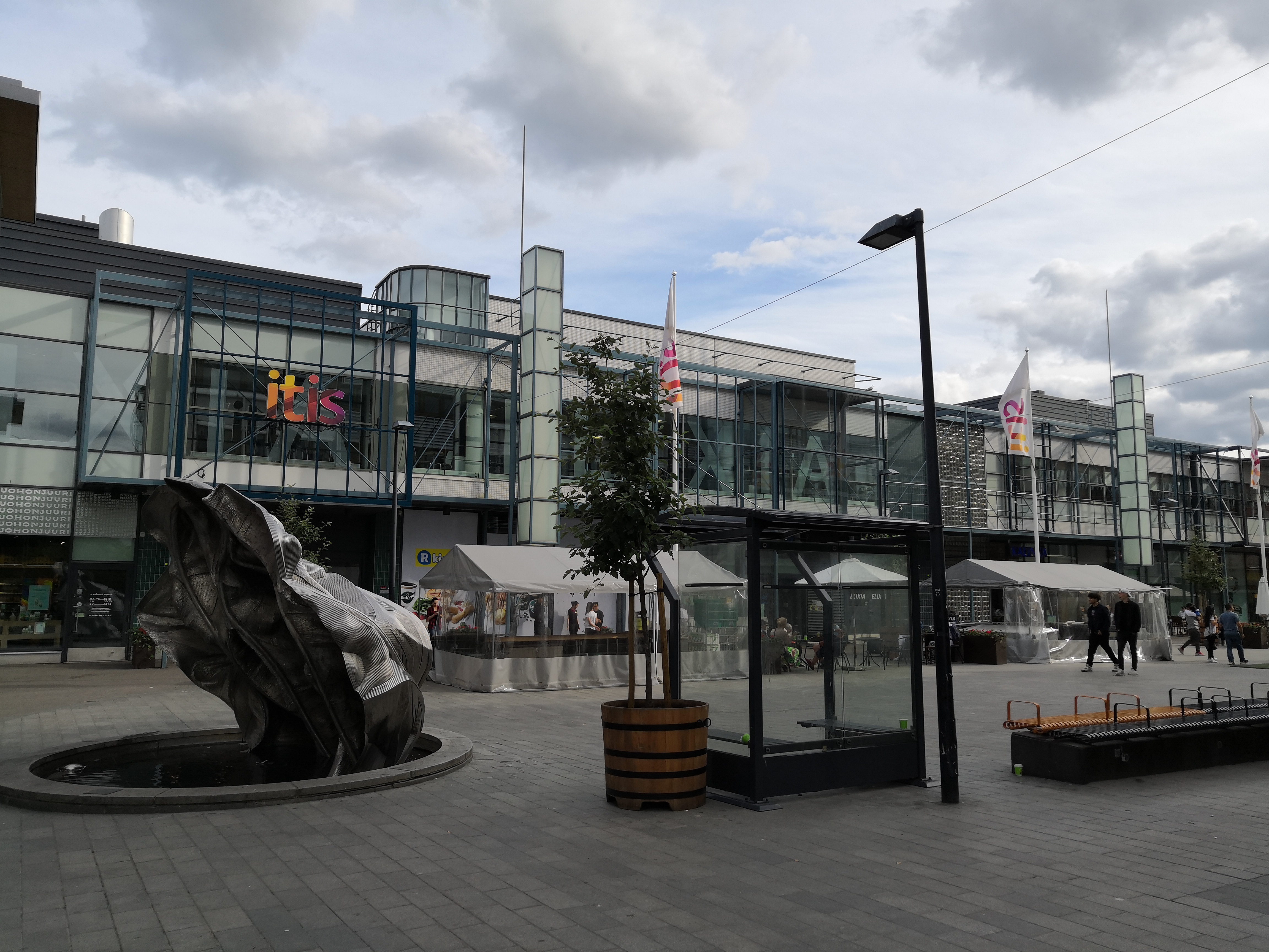 Tallinnanaukio, Itäkeskus. Taustalla Itiksen kauppakeskus, Tallinnanaukio 3. Edustalla Kimmo Schroderuksen veistos "Kuru", 2006. rephoto