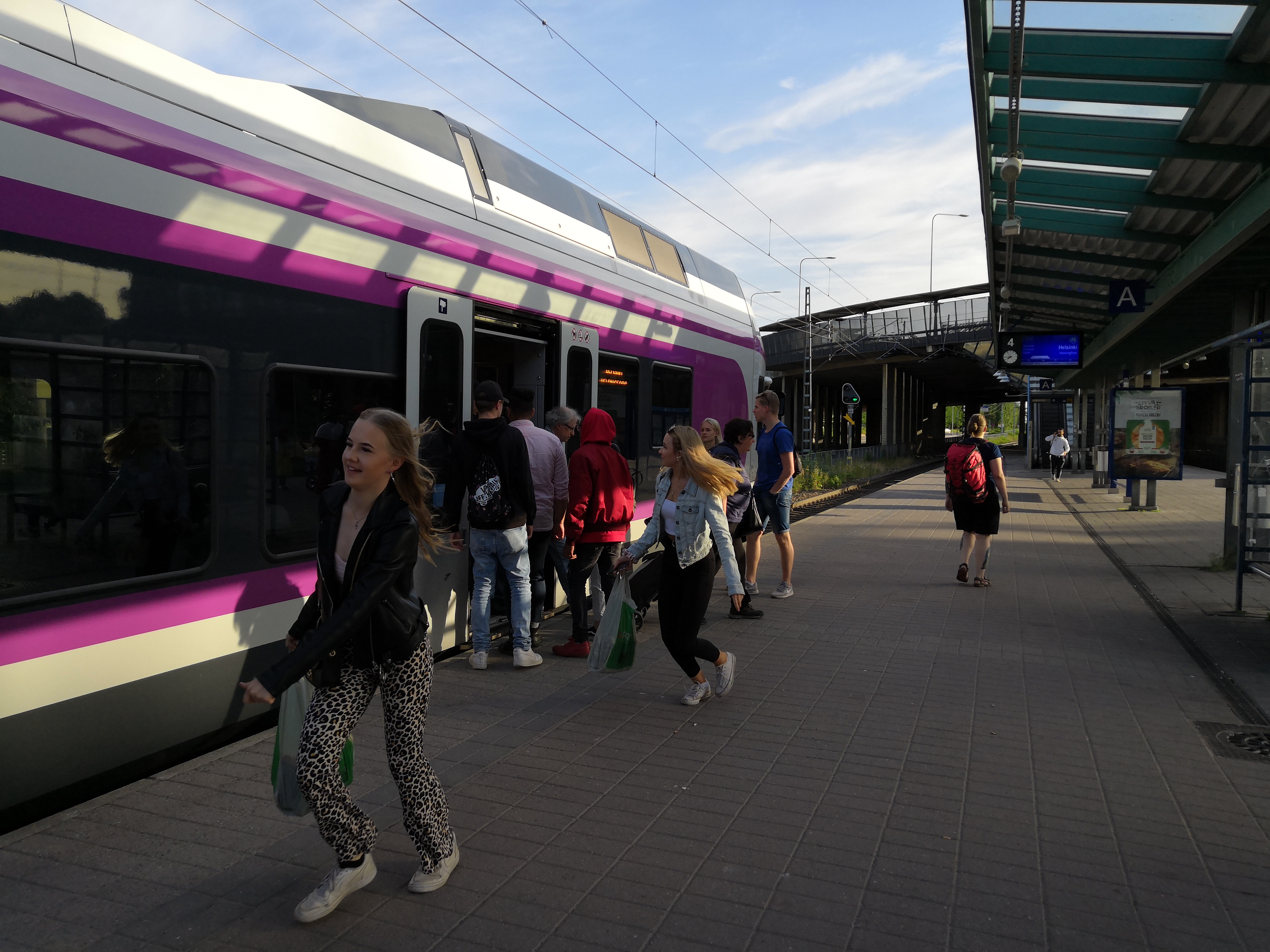Lähiliikenteen juna ja matkustajia Malmin asemalla. rephoto