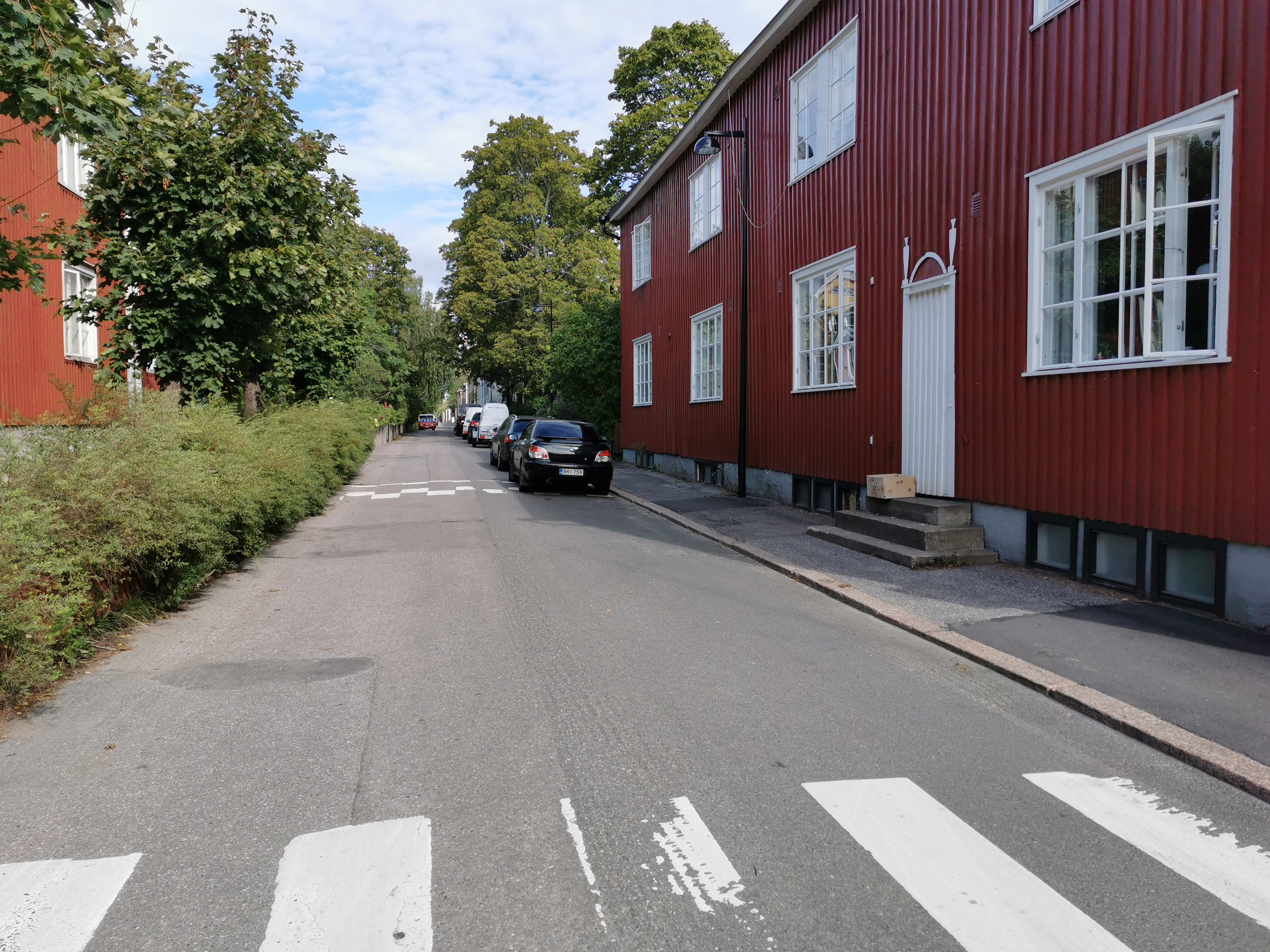 Limingantie 9. Katunäkymä Limingantieltä Jyrängöntien kulmasta koilliseen kevätauringon sulattaessa lumia. Oikealla olevissa kaksikerroksisissa puutaloissa myymälöitä, edessä Limingantie 9:ssä H.M. Laineen K-kauppa. rephoto