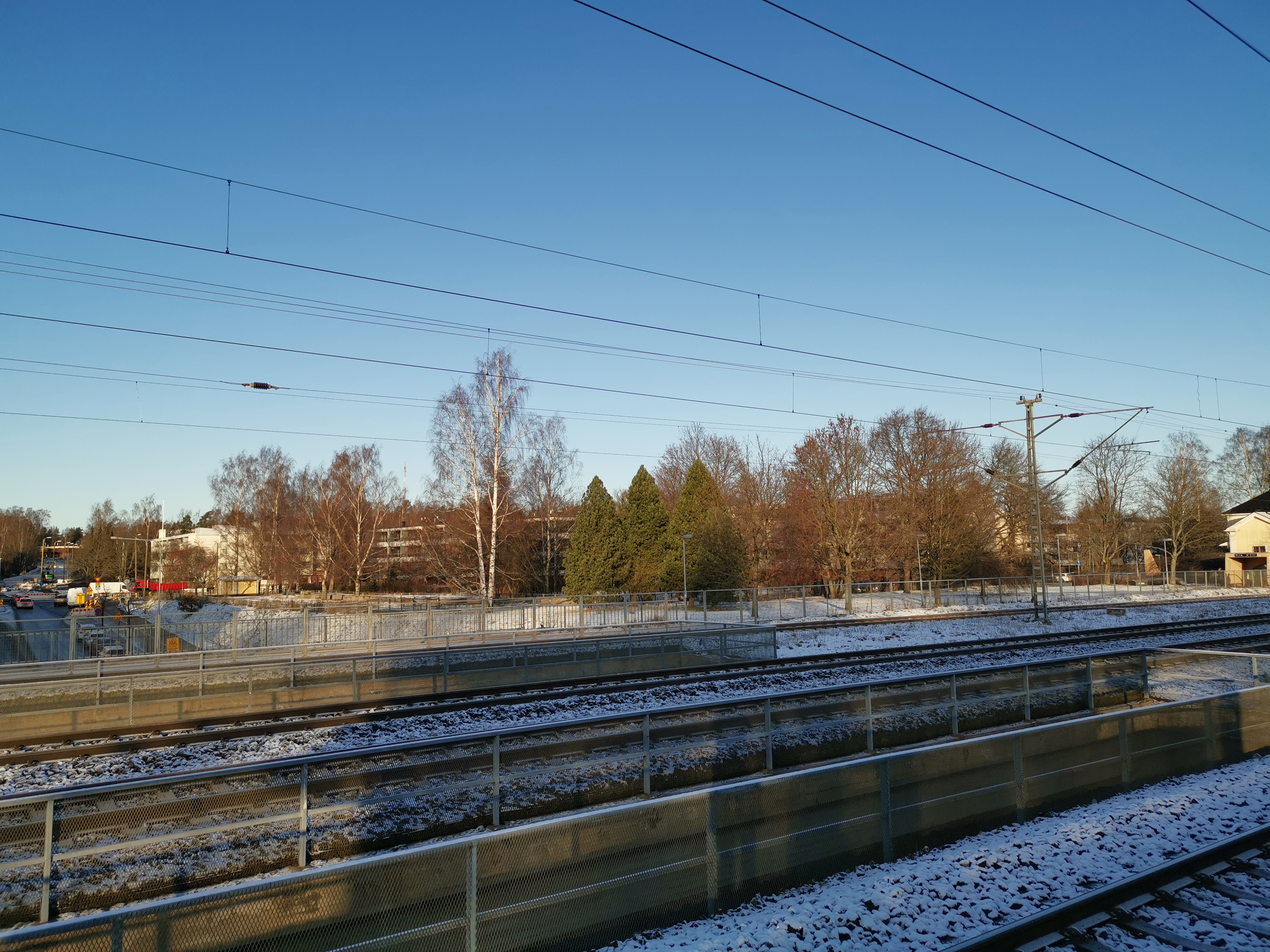 Oulunkylä, näkymä rautatieaseman raiteilta luoteeseen, kohti Kottbyn tilaa. Peltojen takana vasemmalla tilan navetta ja keskellä päärakennus (Teinintie 25). Taustalla oikealla Oulunkylän vanha kirkko (Siltavoudintie 12). rephoto