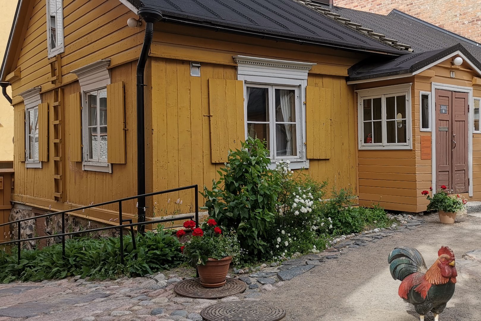 Kristianinkatu 12 pihan puolelta. Vasemmalla Martta Bröyer (Nevalainen). Katolle vieviin tikkaisiin nojaa mahdollisen tulipalon sammuttamisessa käytettävä palohaka. rephoto